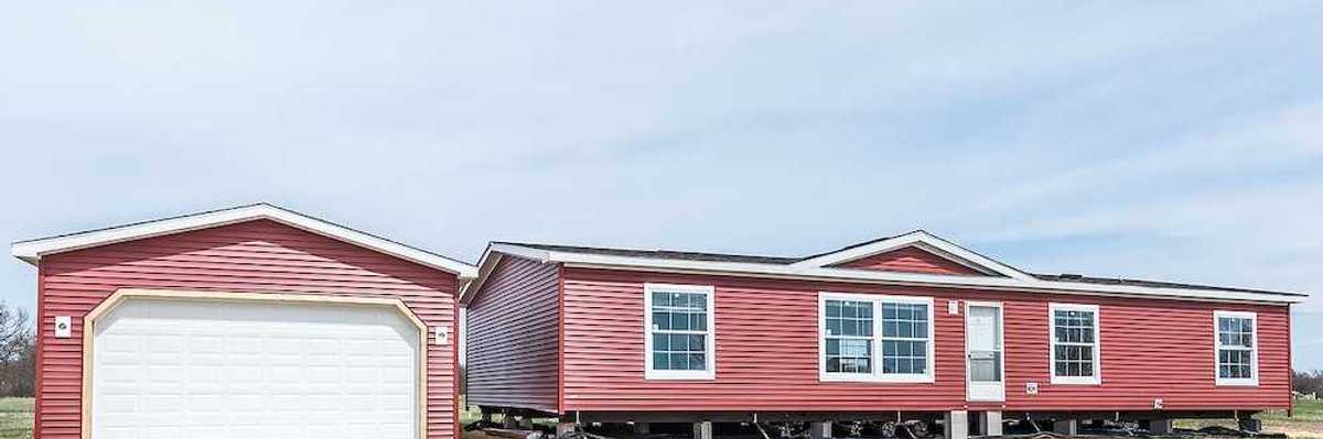 New manufactured home with red vinyl siding and windows