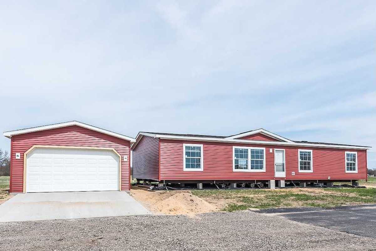 New manufactured home with red vinyl siding and windows