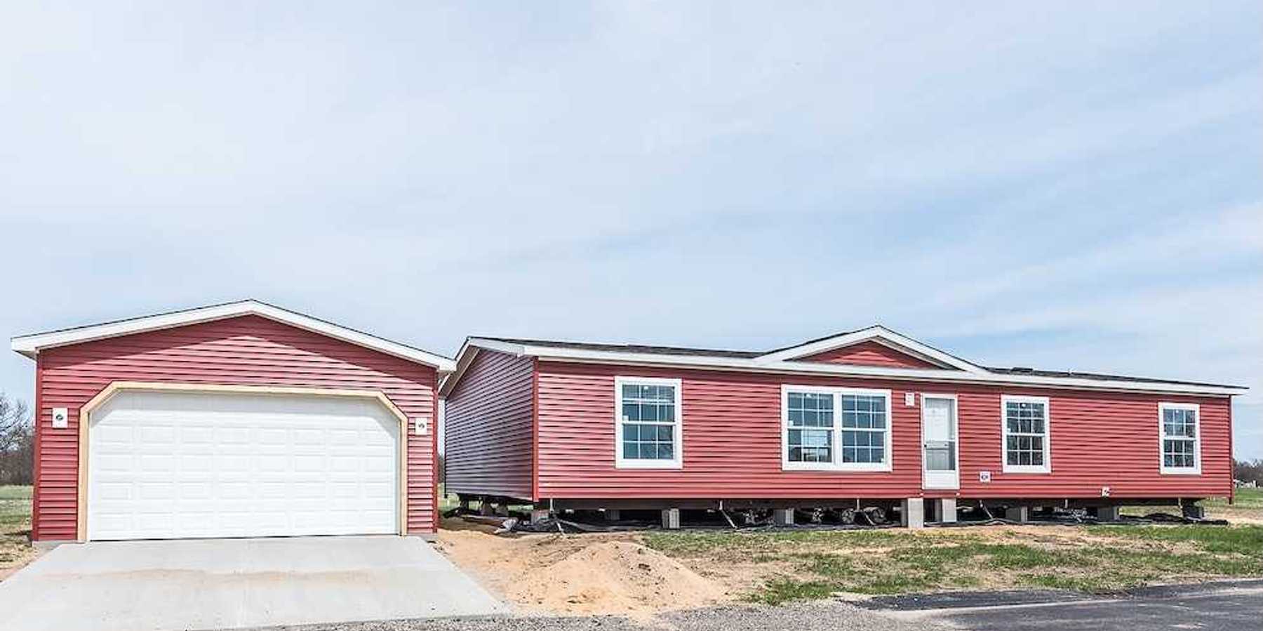 New manufactured home with red vinyl siding and windows