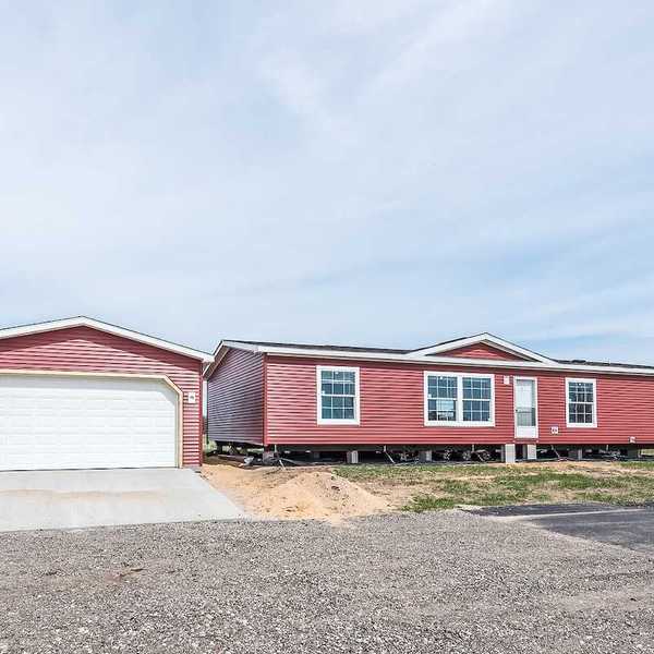 New manufactured home with red vinyl siding and windows