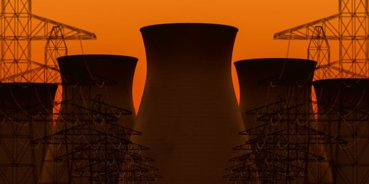 Nuclear towers near electric towers at sunset.