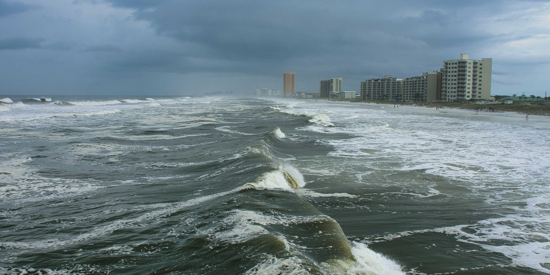 ocean waves near city buildings during daytime