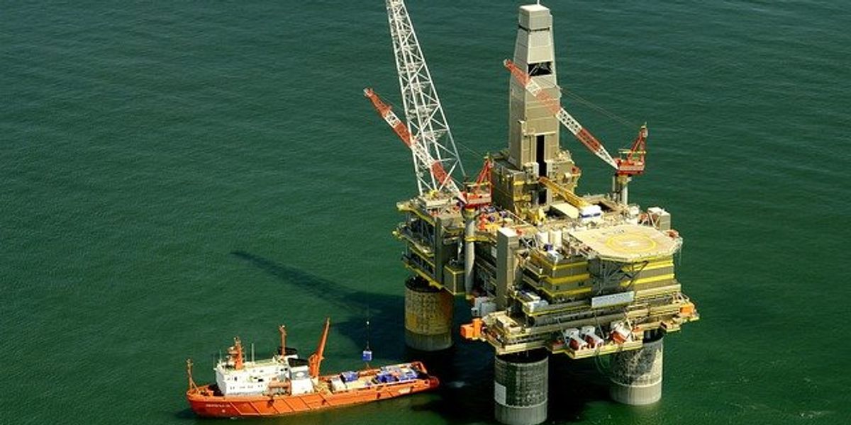 Offshore drilling platform with a boat next to it.