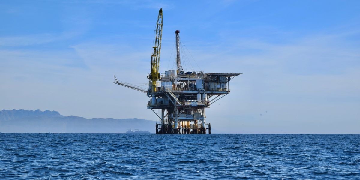 Offshore oil rig with mountains in the background.