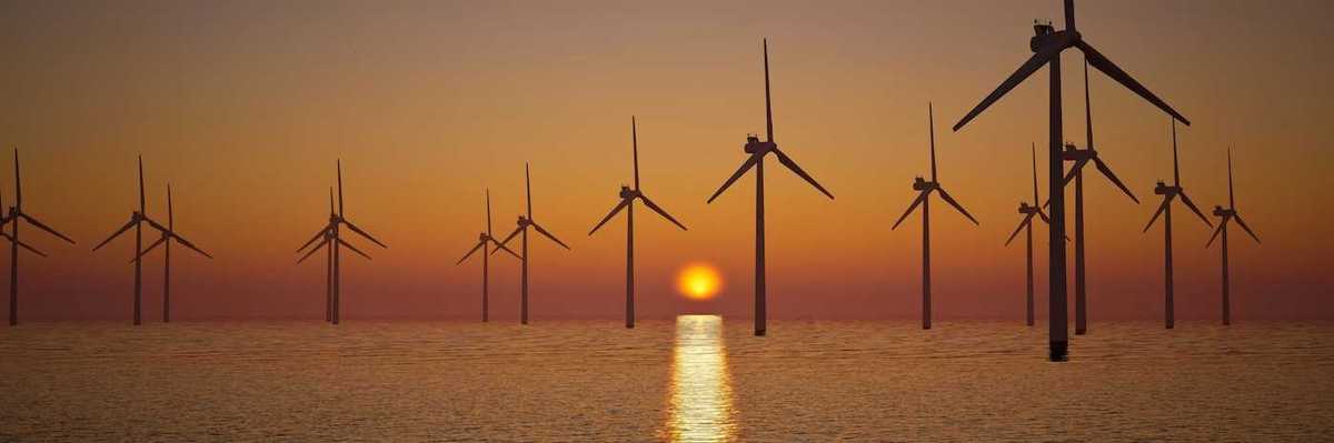 Offshore wind turbines against setting sun