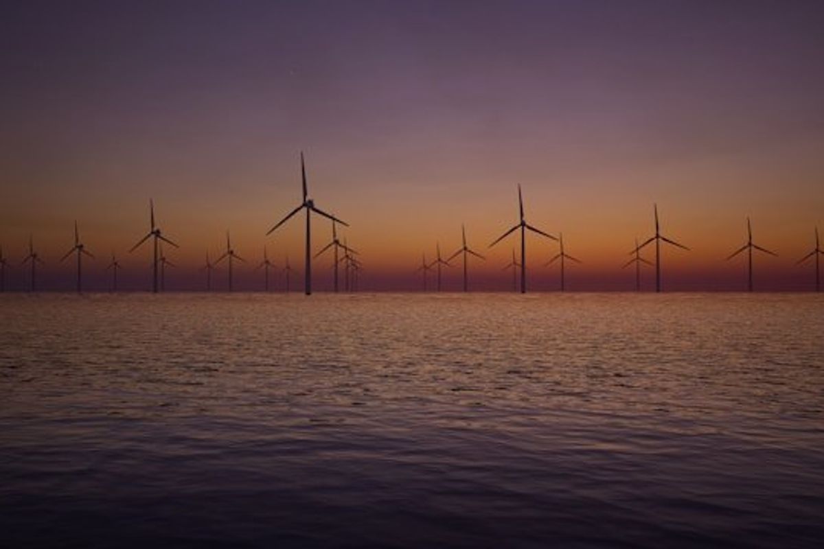 Offshore wind turbines with the sunset in the background.