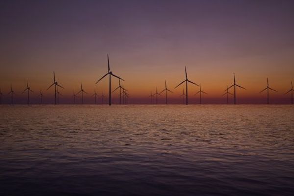 Offshore wind turbines with the sunset in the background.