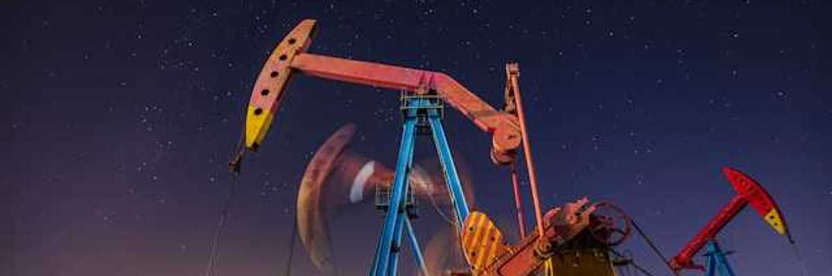 Oil pump jacks at night with a starry sky in the background