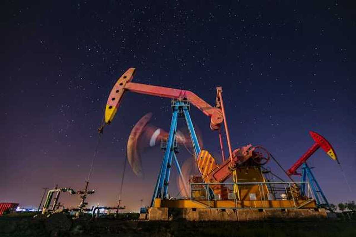 Oil pump jacks at night with a starry sky in the background