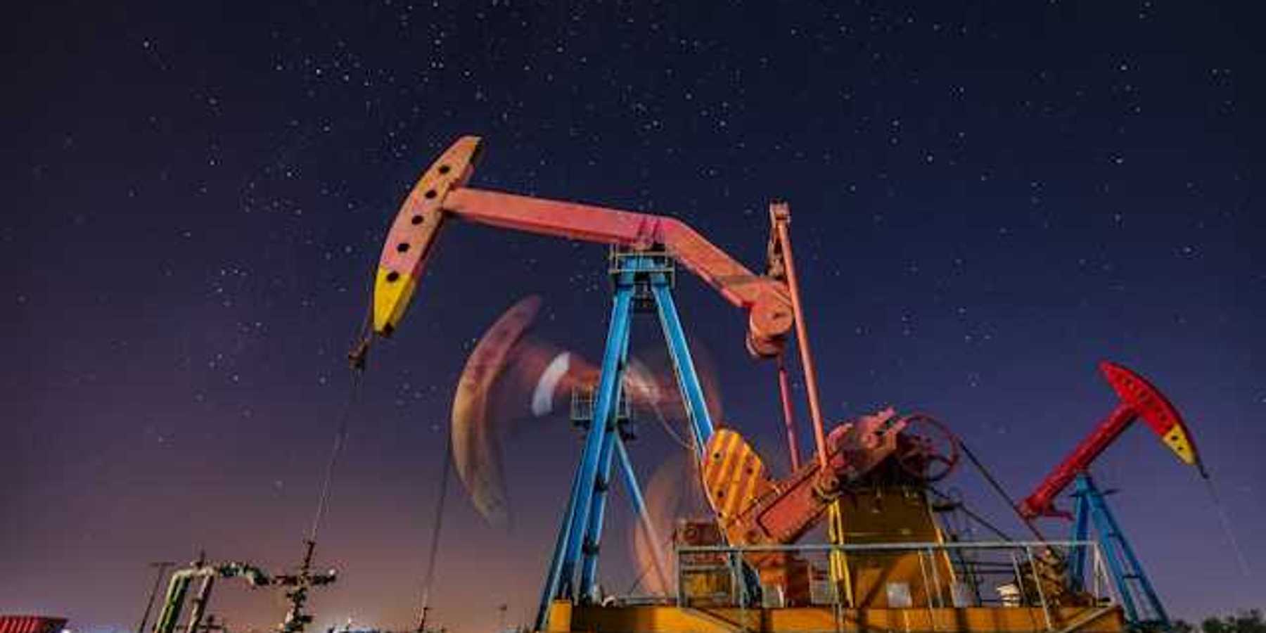 Oil pump jacks at night with a starry sky in the background