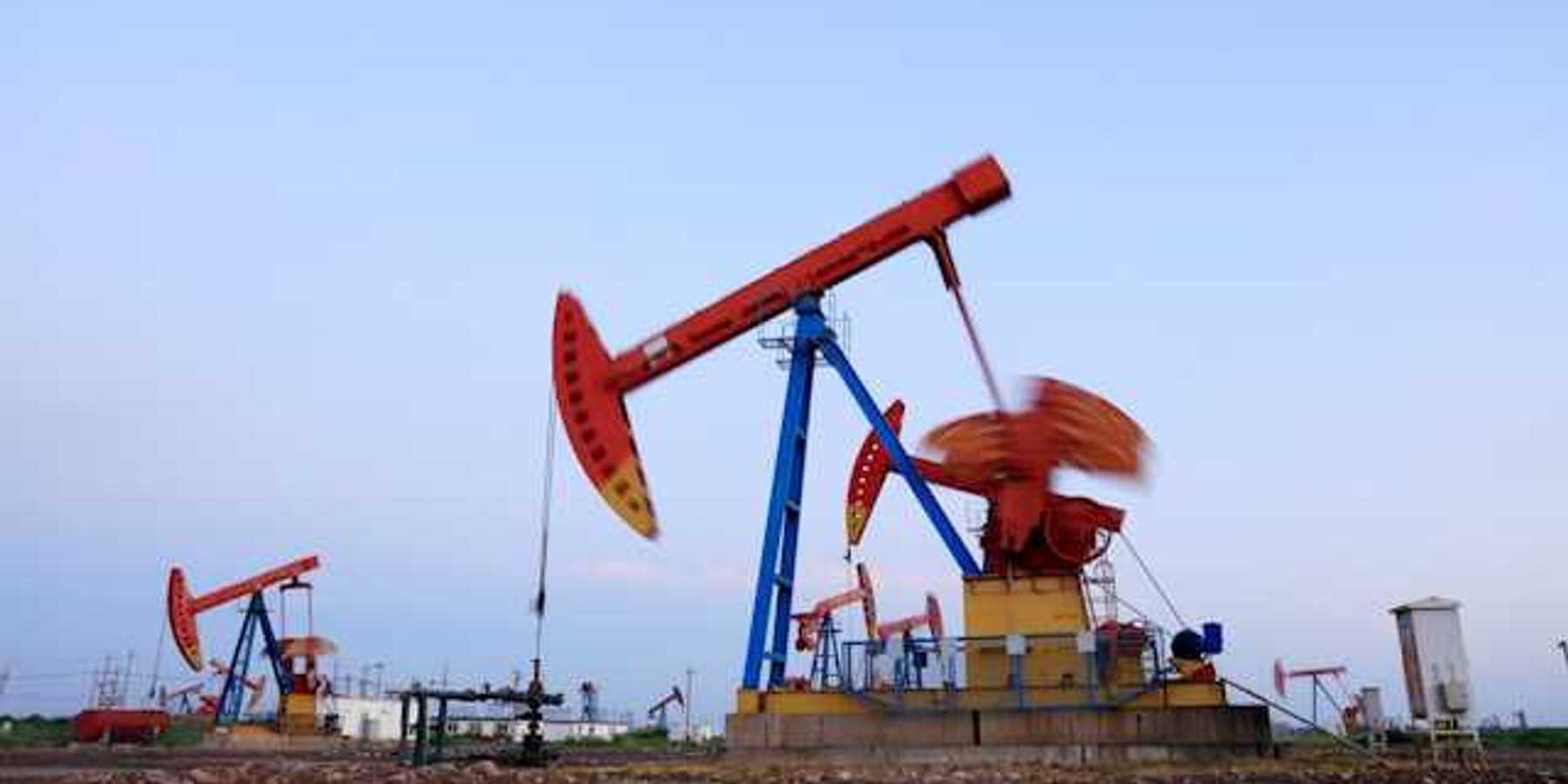 Oil pump jacks drilling for oil in a field