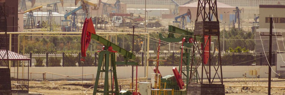 Oil pumps are operating in an industrial landscape.