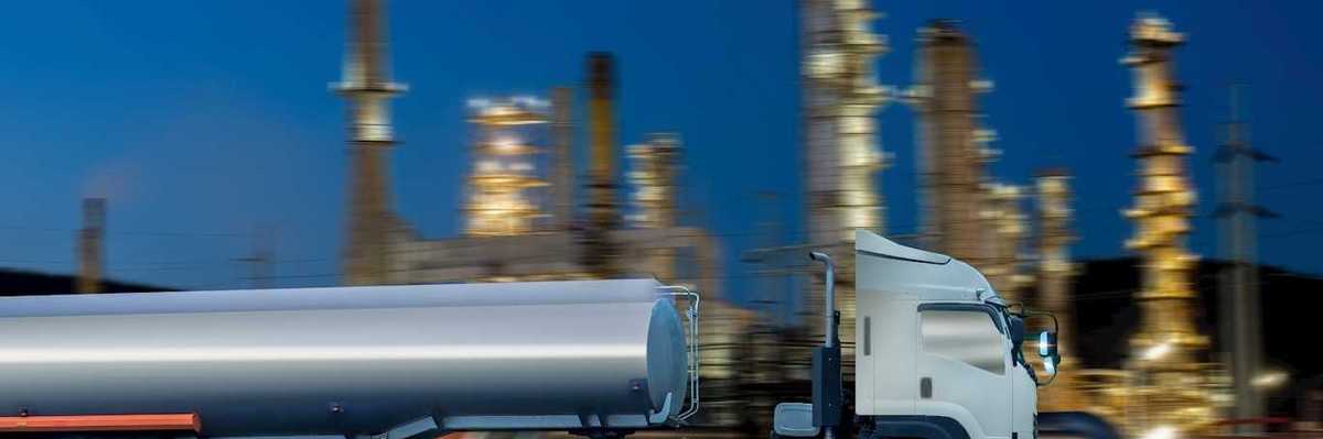 Oil tanker truck in front of a refinery