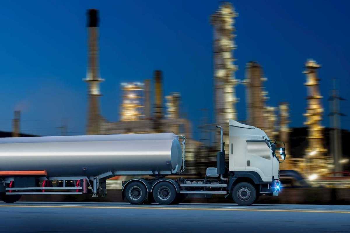 Oil tanker truck in front of a refinery