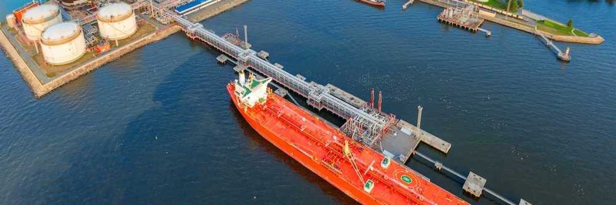 Oil tankers at a terminal full of storage tanks
