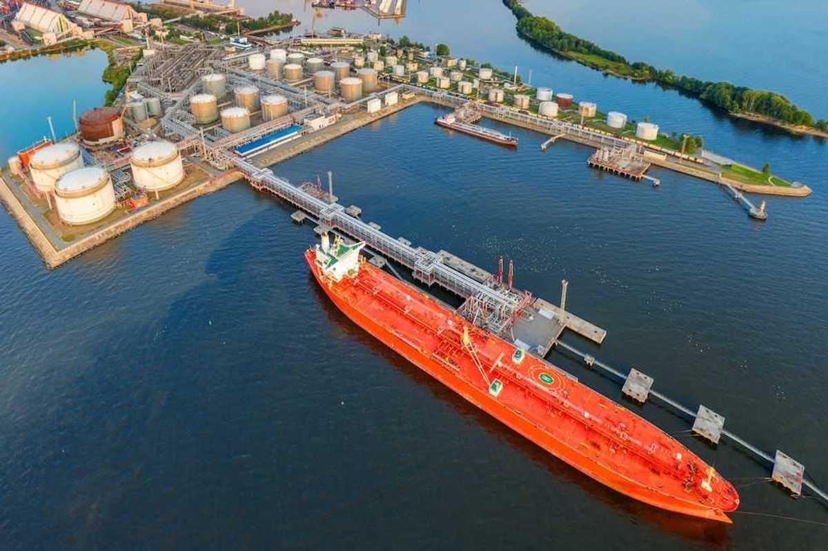 Oil tankers at a terminal full of storage tanks