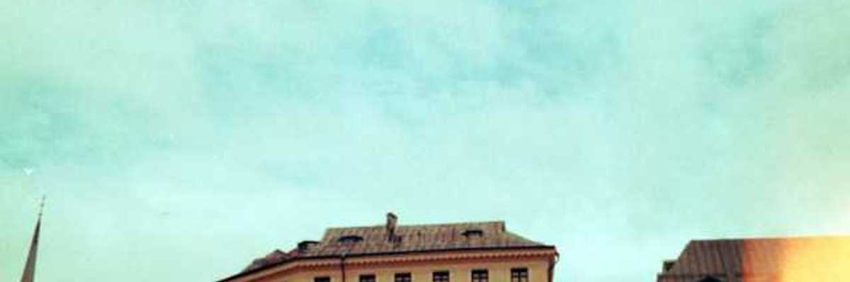 Old buildings stand against a bright blue sky