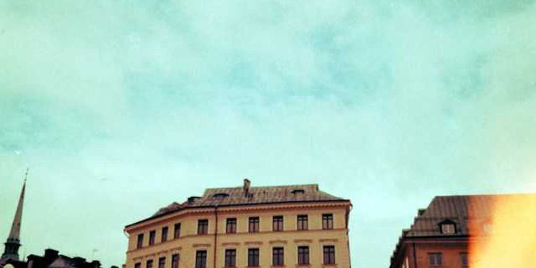 Old buildings stand against a bright blue sky
