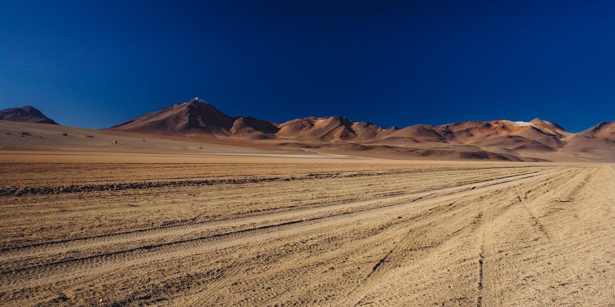open desert landscape with some hills in the background