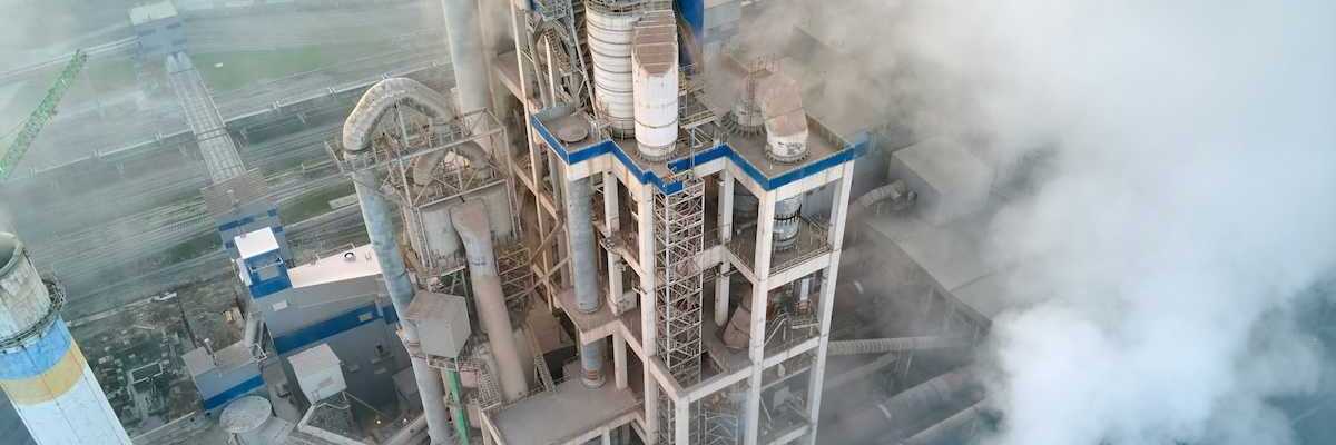 Overhead shot of a cement making facility engulfed in emissions