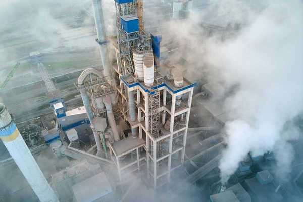 Overhead shot of a cement-making facility engulfed in emissions