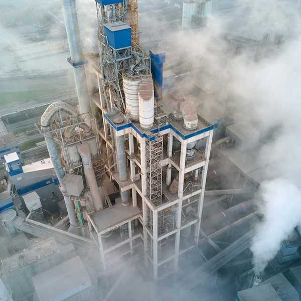Overhead shot of a cement-making facility engulfed in emissions