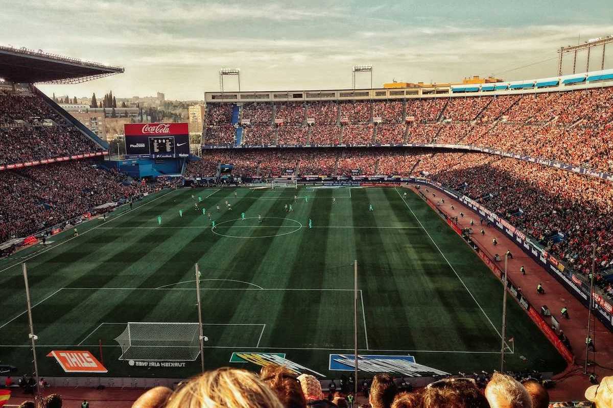 Packed soccer stadium with signage advertising various corporate sponsors