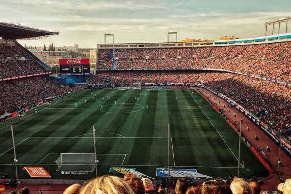 Packed soccer stadium with signage advertising various corporate sponsors