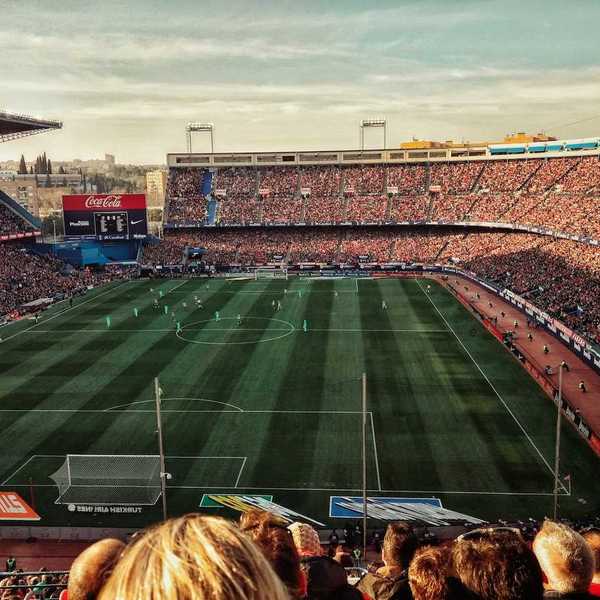 Packed soccer stadium with signage advertising various corporate sponsors
