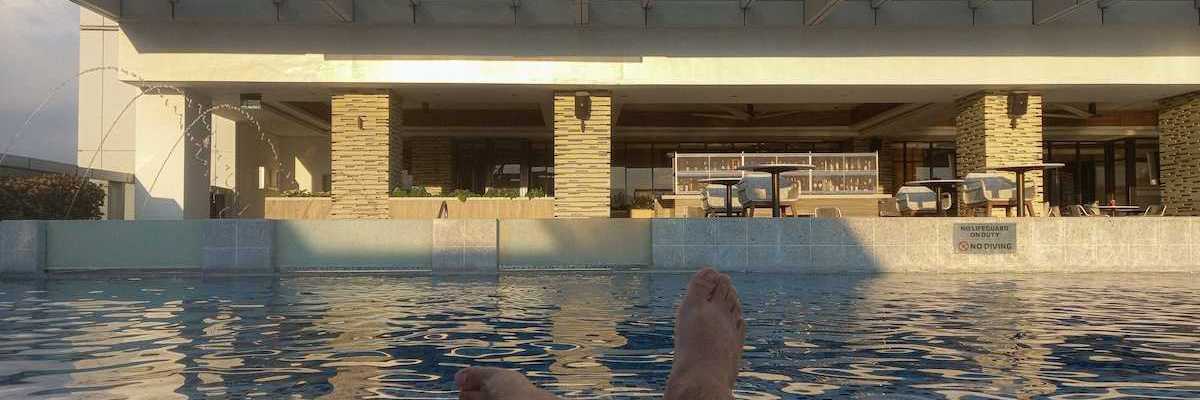 Pair of feet belonging to a person lounging poolside
