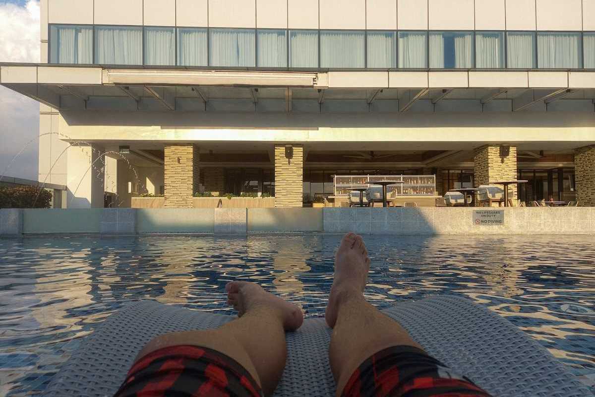 Pair of feet belonging to a person lounging poolside