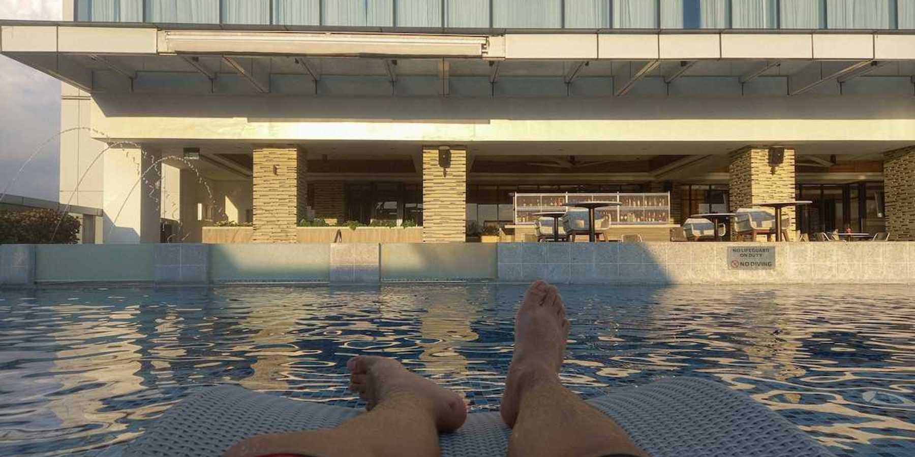 Pair of feet belonging to a person lounging poolside