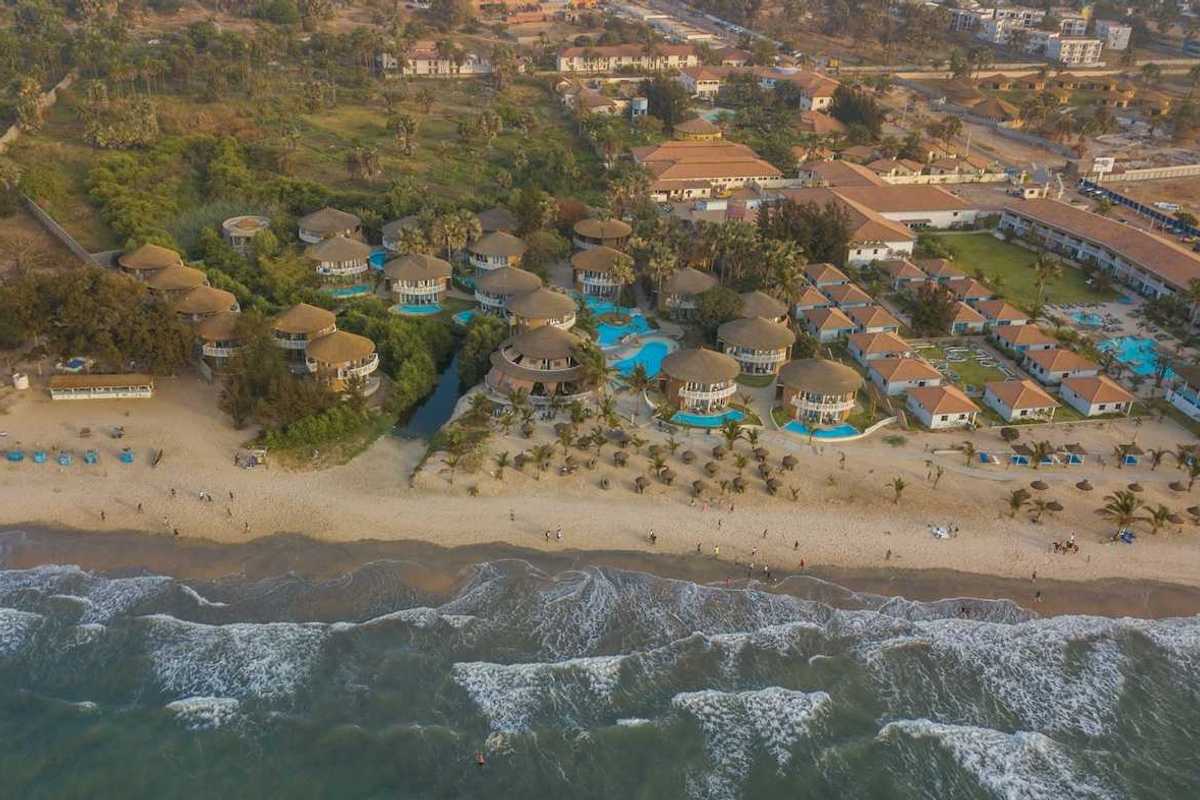 Panoramic drone view of Balafon Beach Resort on Kololi Beach in Gambia shows close proximity of ocean and inland residences
