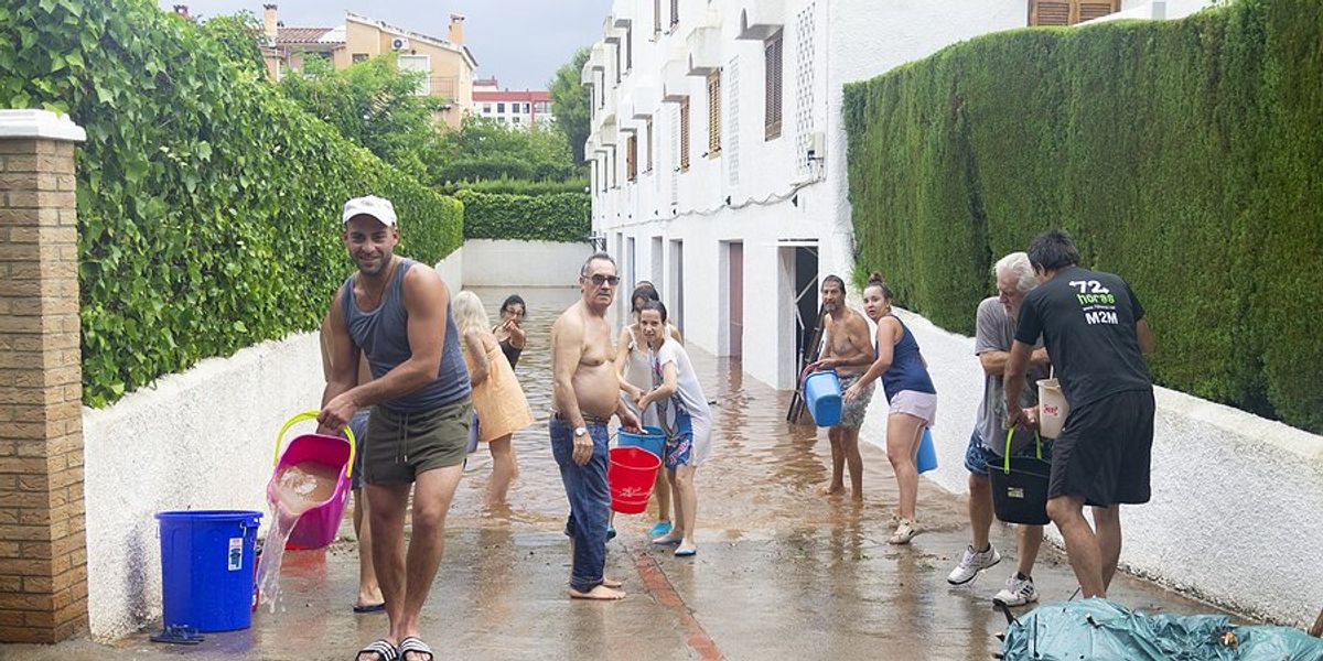 people clearing driveway flooding with buckets