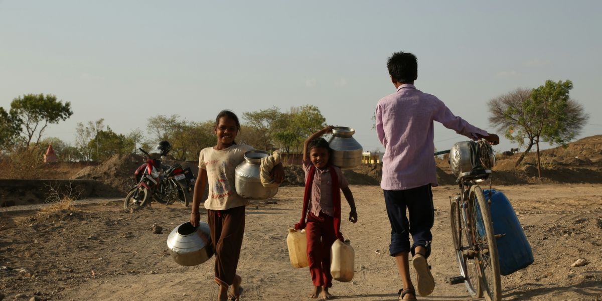 people hauling water on dry dirt road