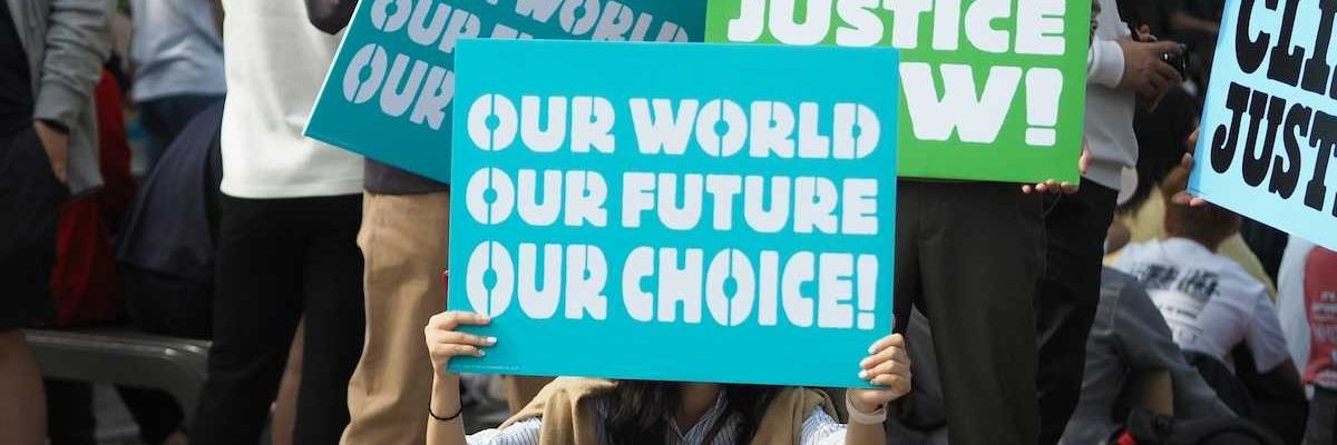 People holding Climate Justice signs "Our World Our Future Our Choice'