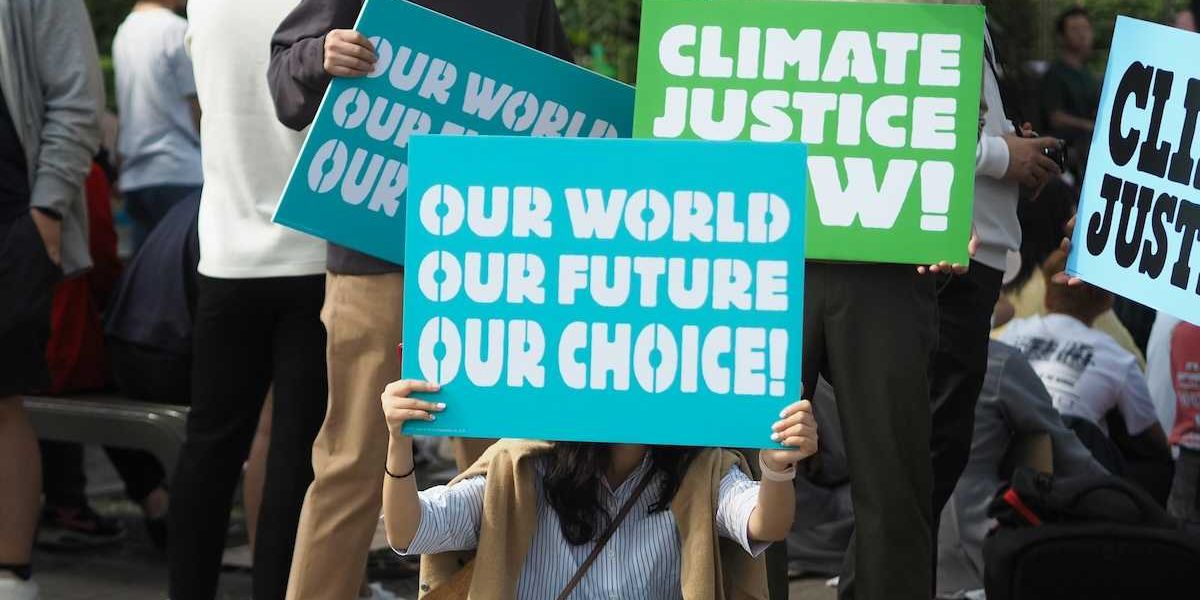 People holding Climate Justice signs "Our World Our Future Our Choice'