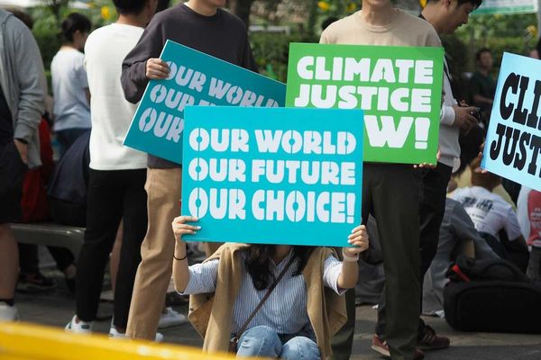 People holding Climate Justice signs "Our World Our Future Our Choice'