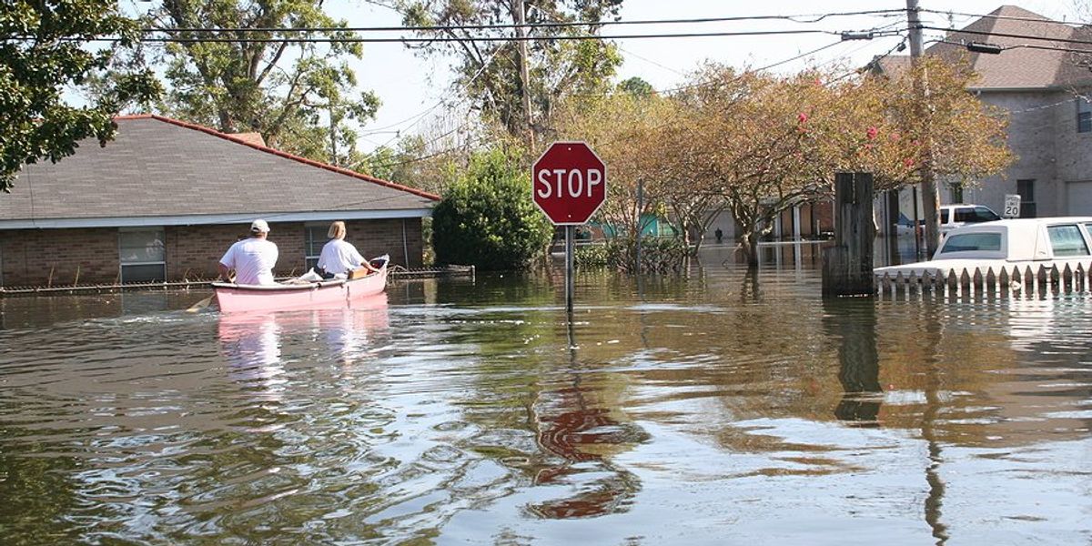 people in a canoe in a flooded neighborhood