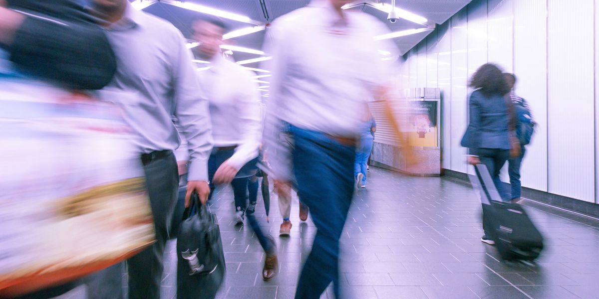 People walking through a subway hallway in a blur.