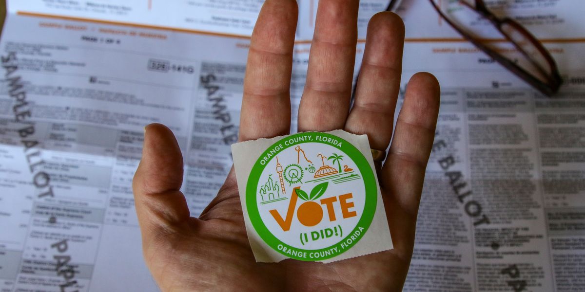person holding "Vote (I DID!) sticker