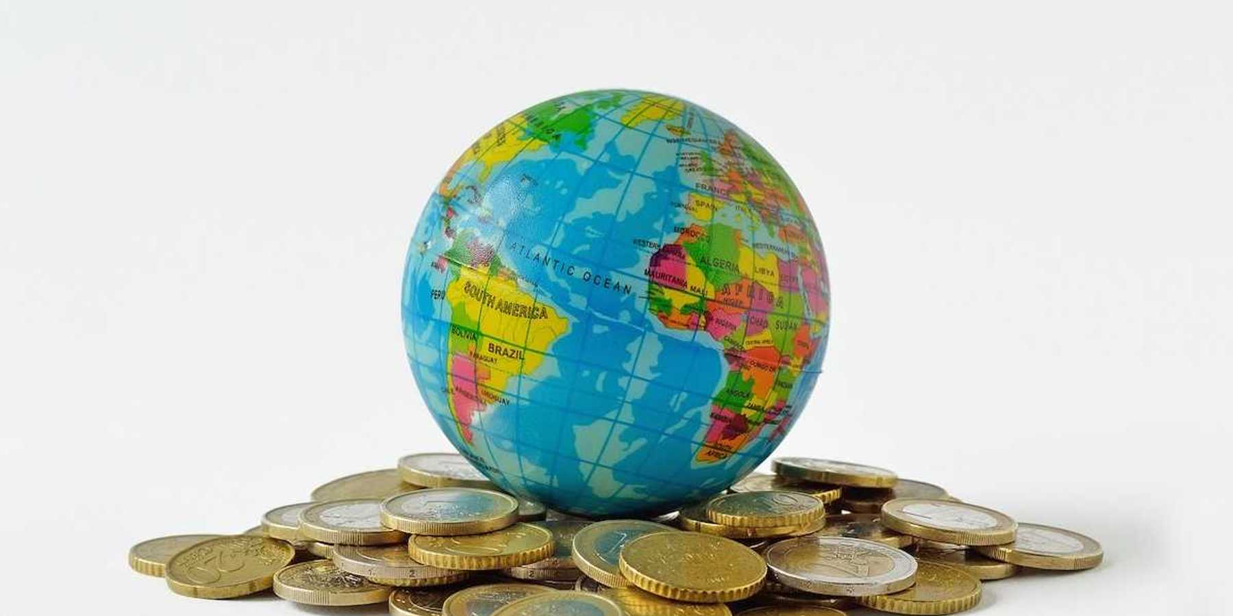 Planet earth on pile of coins - Concept of relationship between money, economic growth and planet earth