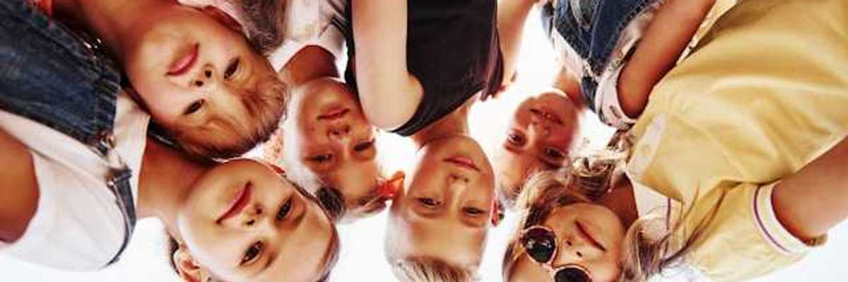 Portrait of a group of kids huddled together with a soccer ball