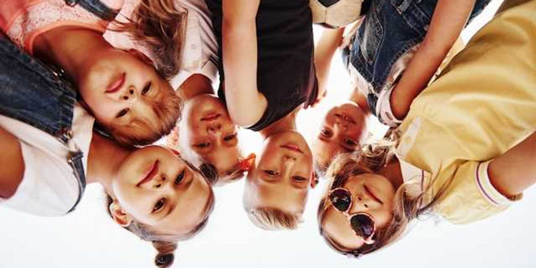 Portrait of a group of kids huddled together with a soccer ball