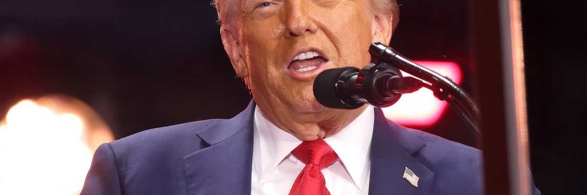 President Donald Trump speaking into a microphone
