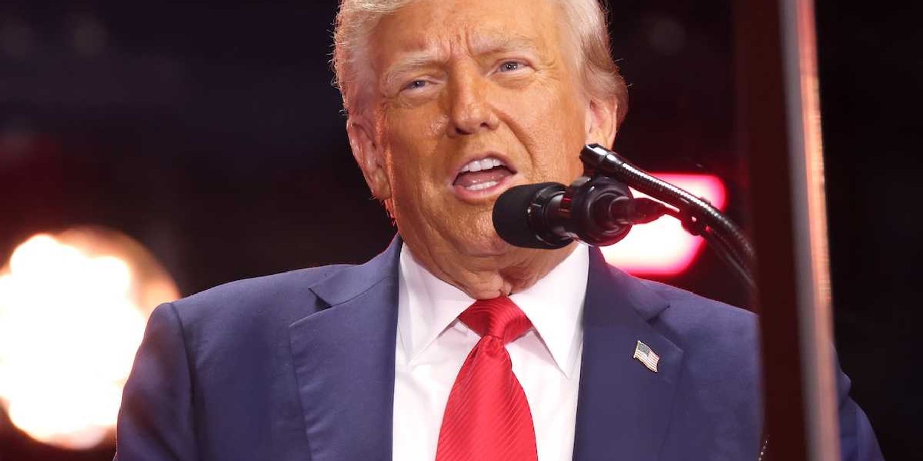 President Donald Trump speaking into a microphone