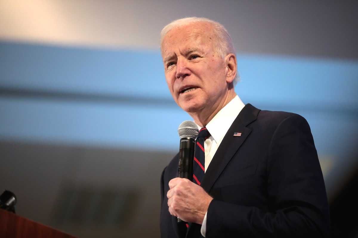 President Joe Biden speaking while holding a microphone