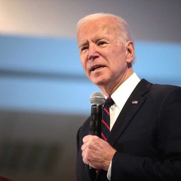 President Joe Biden speaking while holding a microphone