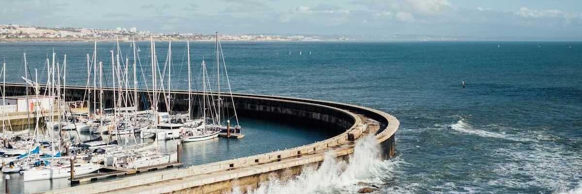 Protective sea wall sheltering multiple boats at harbor