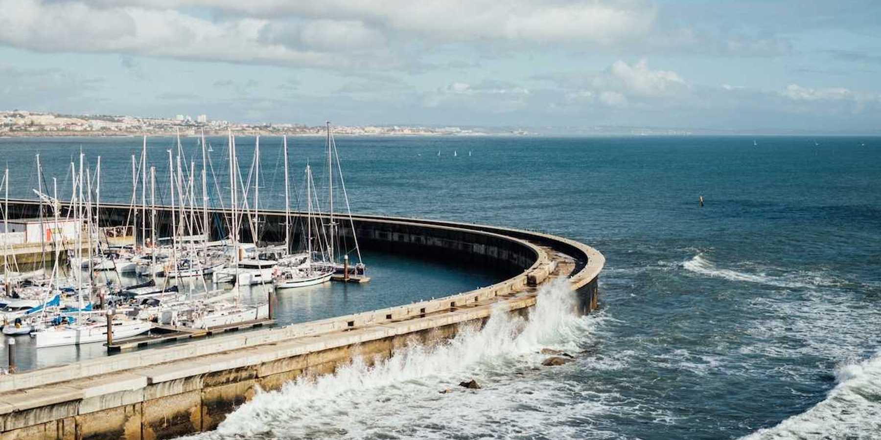 Protective sea wall sheltering multiple boats at harbor